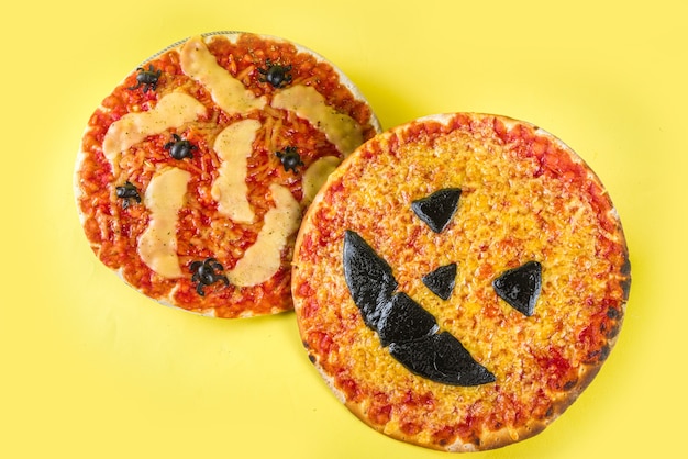 Halloween-feest trick or treat-eten, grappige enge pizza in de stijl van halloween-personages - vleermuizen, spinnen, jack o lantern pompoen, cheddar, mozzarella en zwarte kaas