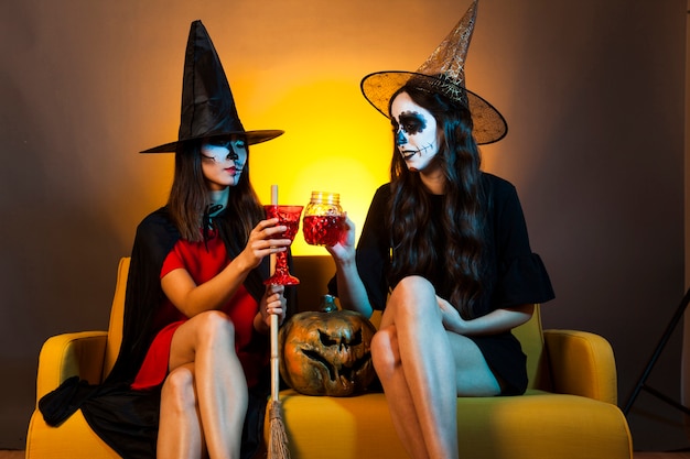 Gratis foto halloween meisjes op de bank met drankjes