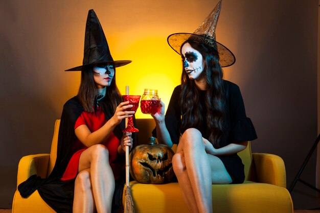 Halloween meisjes op de bank met drankjes