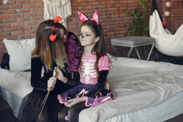 Halloween. Moeder en dochter in Halloween-kostuum. Familie thuis.