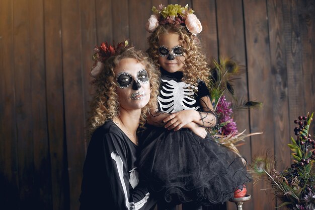 Halloween. Moeder en dochter in Halloween-kostuum in Mexicaanse stijl. Familie thuis.