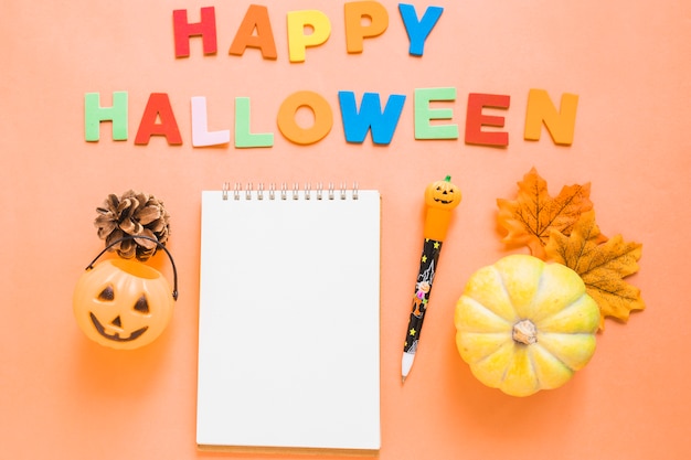 Gratis foto halloween-symbolen dichtbij het schrijven en kantoorbehoeften