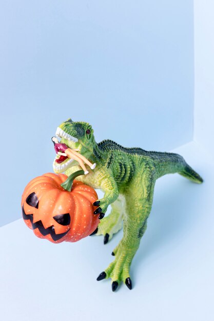 Halloween van de close-up dinosaurusstuk speelgoed holdingspompoen