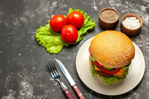 Halve bovenaanzicht vlees hamburger met groenten en salade op donkere ondergrond broodje sandwich fastfood