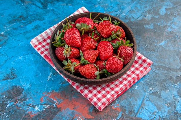 Halve bovenaanzichtplaat met aardbeien, vers, smakelijk, rijp fruit op blauwe achtergrond, zomerfoto, kleur, boom, rood, wilde bes