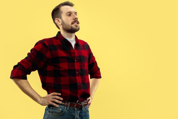 Gratis foto halve lengte close-up portret van een jonge man op gele muur.