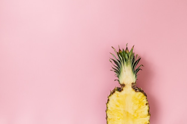 Halve plakje mooie verse smakelijke smakelijke ananas op roze achtergrond. Bovenaanzicht. Horizontaal. Copy Space. Conceptuele.