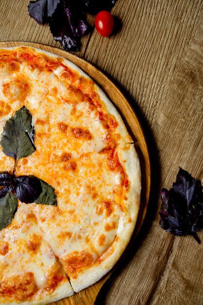Halve uitzicht op margarita pizza versierd met basilicum