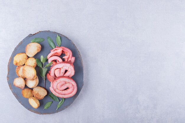 Hambroodjes en gebakken aardappelen op een stuk hout.