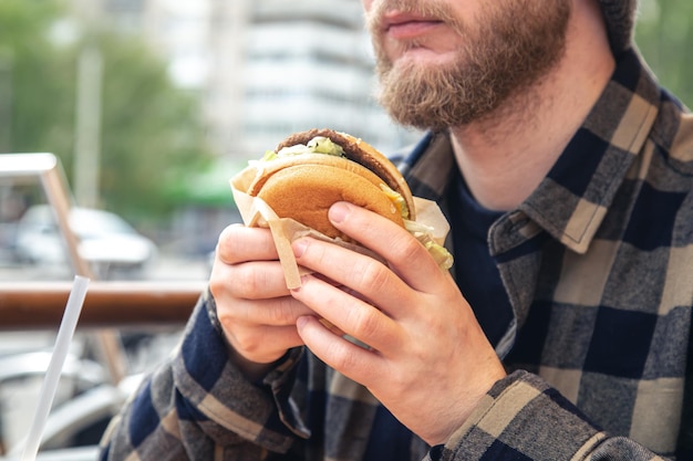 Gratis foto hamburger in mannelijke handen close-up in een fastfood café