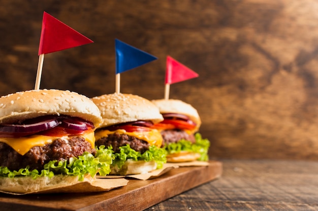 Hamburgers met gekleurde vlaggen op houten dienblad