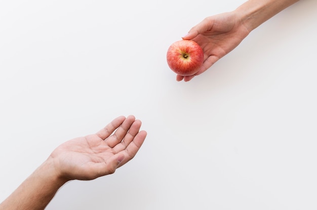 Hand die een appel aan behoeftige persoon geeft