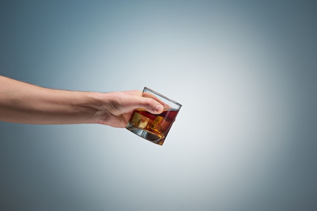 Hand die een glas whisky houdt