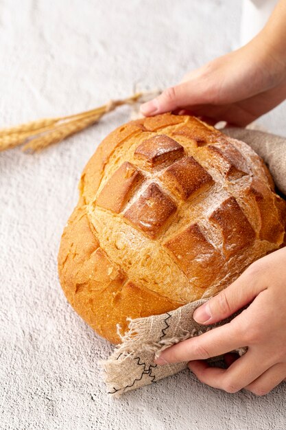 Hand die heerlijke gebakken brood en jutedoek houdt
