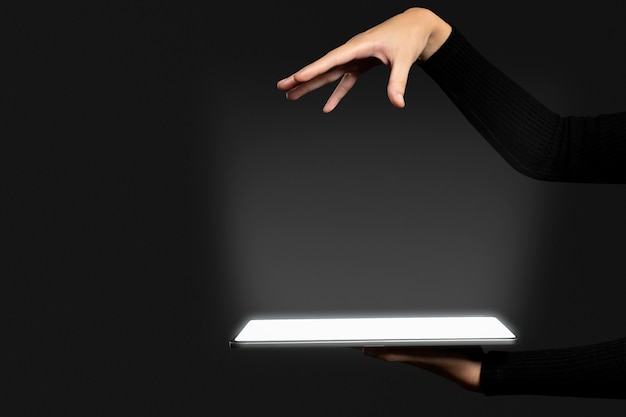 Hand die onzichtbaar hologram presenteert dat wordt geprojecteerd vanuit geavanceerde tablettechnologie