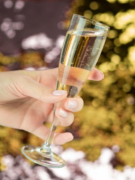 Hand die volledig glas bruisende champagne houdt