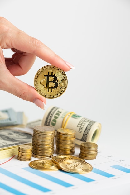 Gratis foto hand met bitcoin boven munt stapel