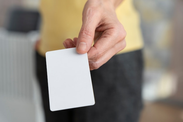 Hand met blanco visitekaartje hoge hoek