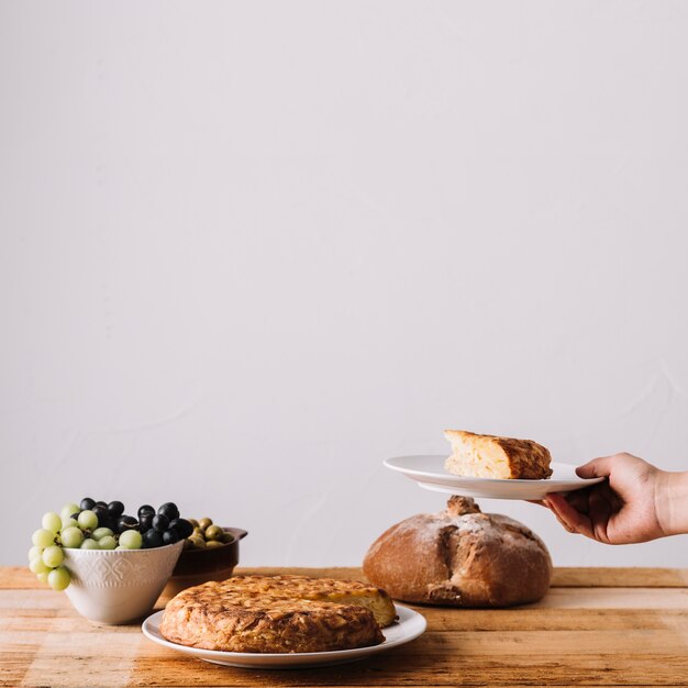 Hand met cake over tafel