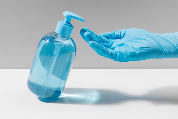 Hand met chirurgische handschoen met handdesinfecterend middel