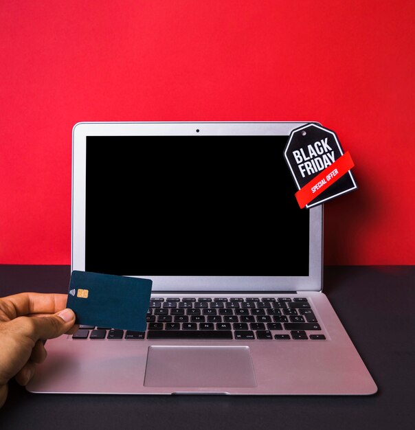 Hand met creditcard dichtbij laptop met teken