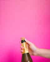 Gratis foto hand met een fles champagne