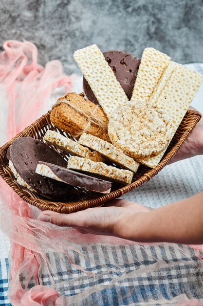 Hand met een mand met gemengde koekjes.