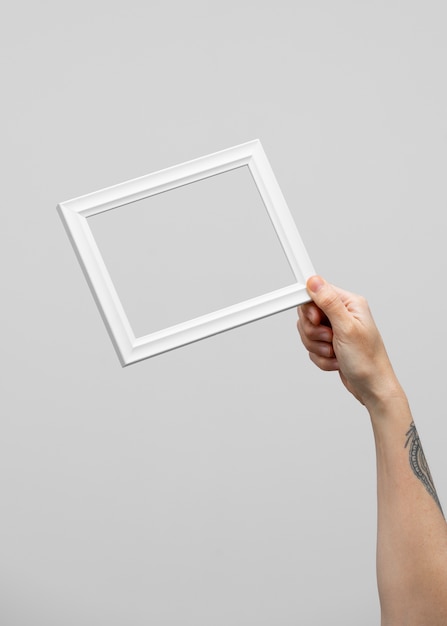 Gratis foto hand met klein wit frame