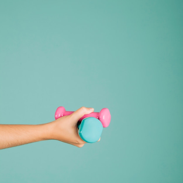 Hand met kleurrijke dumbbells