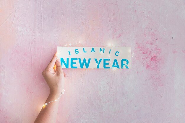 Hand met slinger bedrijf islamitische nieuwjaars papier