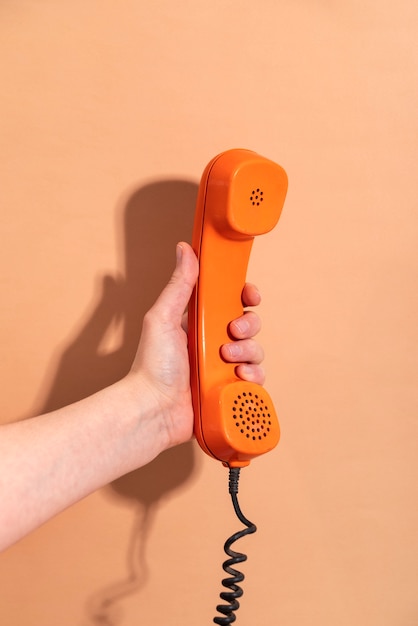 Hand met telefoon met oranje achtergrond