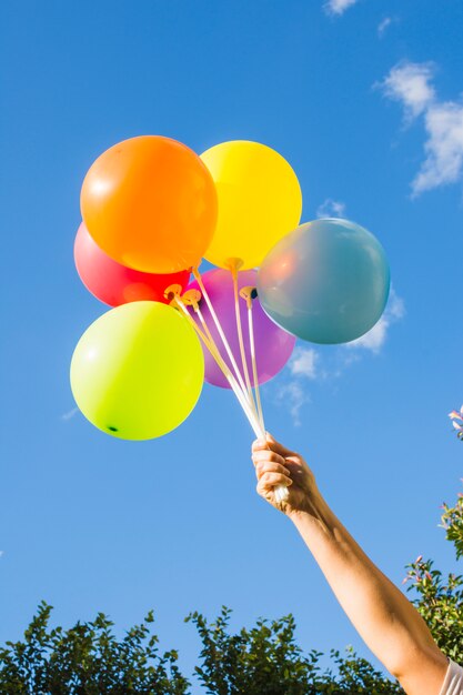 Hand met verzameling van heldere ballonnen