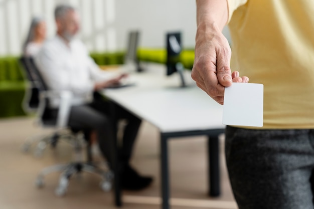 Gratis foto hand met visitekaartje op het werk