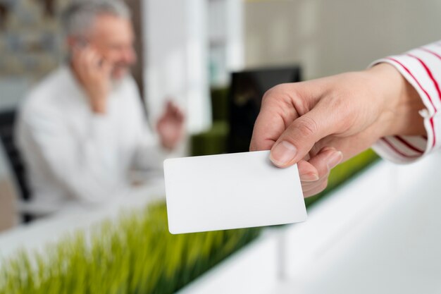 Hand met visitekaartje op kantoor