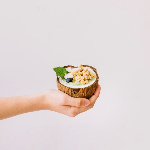 Hand met zomer smoothie in de hand kokosnoot