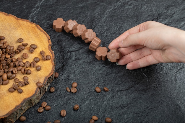 Hand nemen chocoladesuikergoed op zwart.