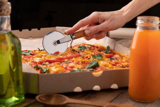 Hand snijden pizza met gereedschap close-up