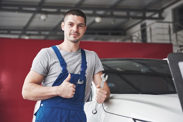 Hand van automonteur met moersleutel. Auto reparatie garage.