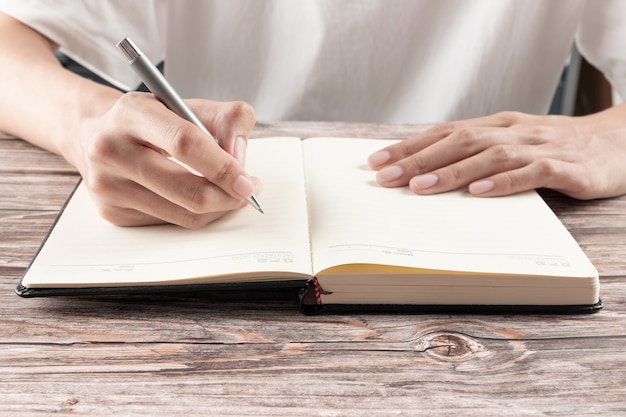 Hand van zakenvrouw schrijven op papier op kantoor