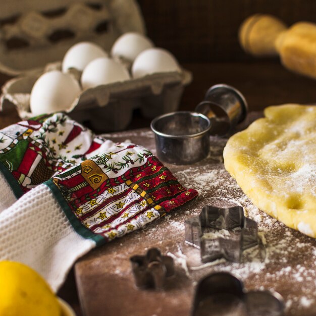 Handdoek in de buurt van cookie cutters en deeg