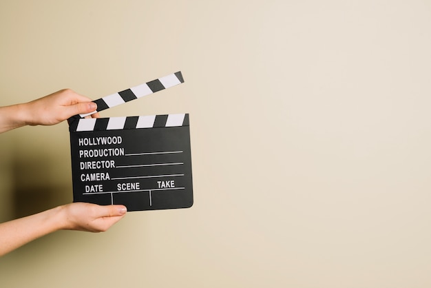 Gratis foto handen bijsnijden met clapperboard