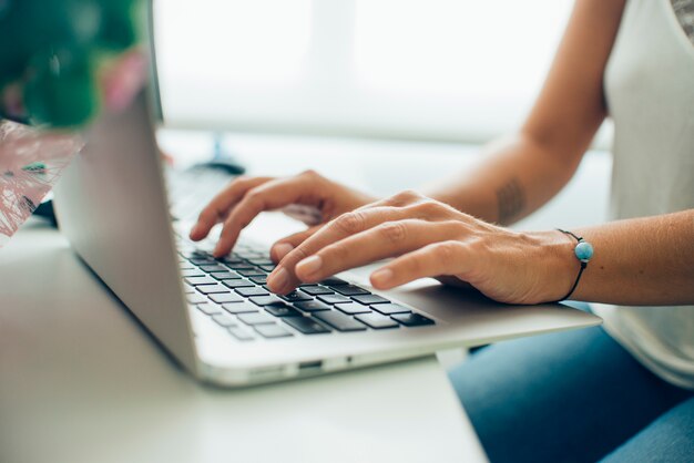 Handen close-up van de drukke ondernemer met haar laptop