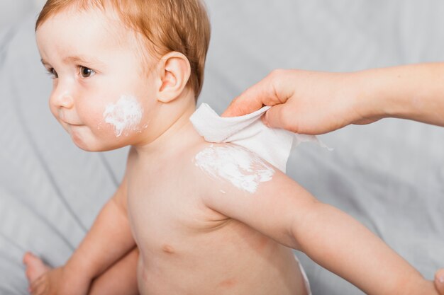 Handen die baby met baby schoonmaken afvegen