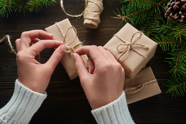 Gratis foto handen die de knoop van de string van giftpakketten