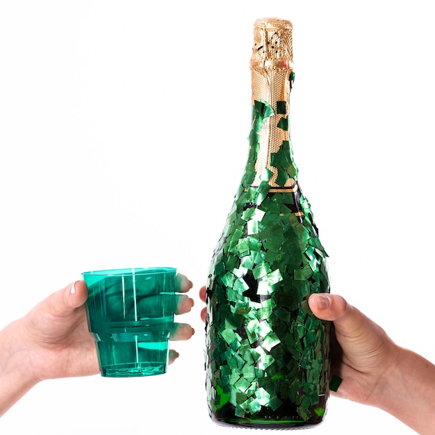 Handen die een glas en een fles champagne houden