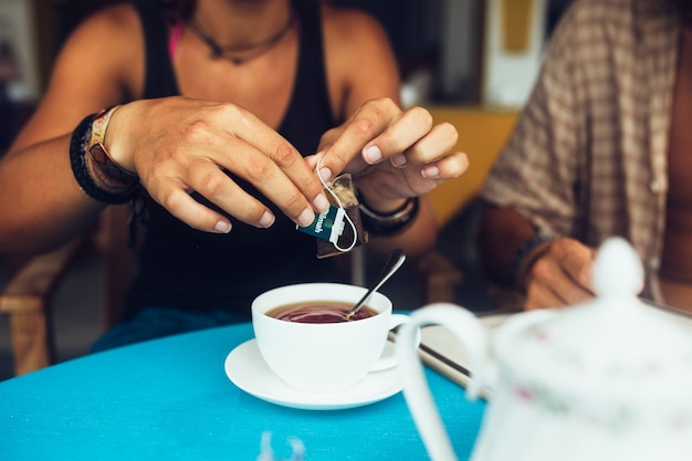 Gratis foto handen die een papieren naast een warme chocolademelk