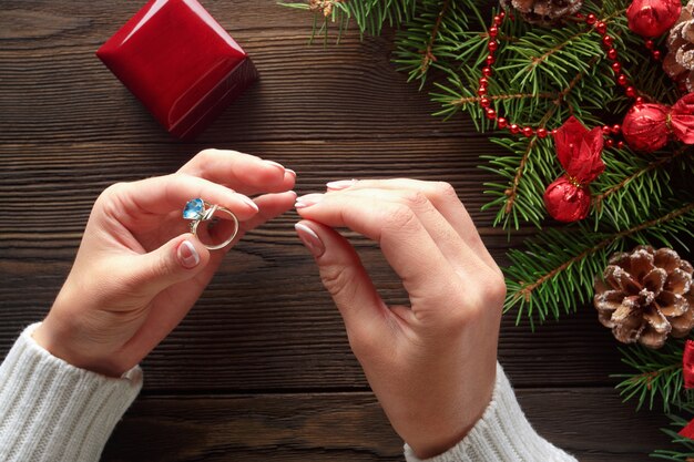 Handen die een ring met een blauwe steen