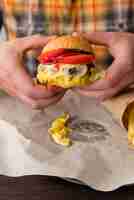 Gratis foto handen die een smakelijke cheeseburger houden