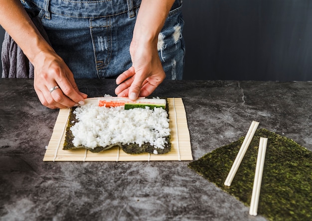 Handen die ingrediënten plaatsen op rijst