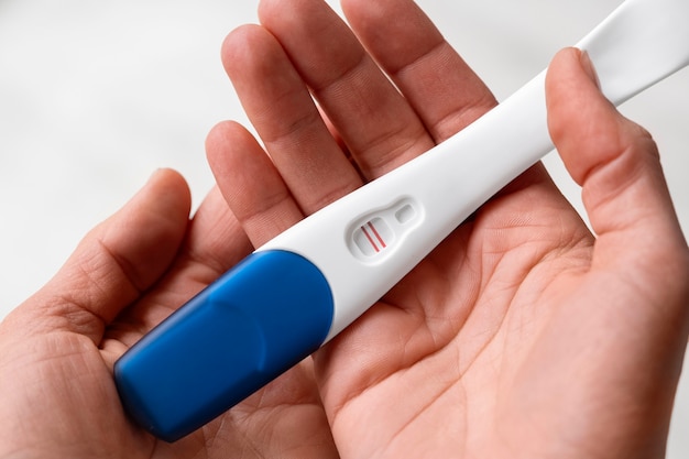 Handen die positieve zwangerschapstest houden